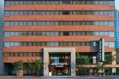 a tall red brick building with a sign in front at Element Calgary Downtown by Westin in Calgary