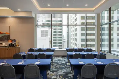 a conference room with blue tables and chairs and large windows at Hampton Inn By Hilton Calgary Downtown in Calgary