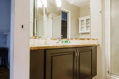a bathroom with a sink and a mirror at entire house THE BLUE DOOR with garage access in Grande Prairie