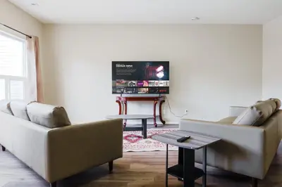 a living room with two couches and a flat screen tv at entire house THE BLUE DOOR with garage access in Grande Prairie