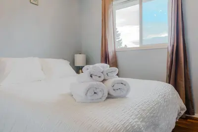 a pile of towels sitting on top of a bed at entire house THE BLUE DOOR with garage access in Grande Prairie