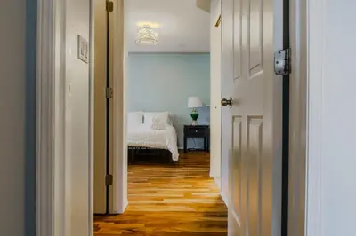 a hallway with a room with a bed and a table at entire house THE BLUE DOOR with garage access in Grande Prairie
