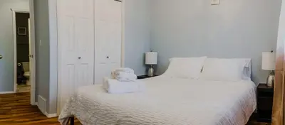 a bedroom with a white bed with a stuffed animal on it at entire house THE BLUE DOOR with garage access in Grande Prairie