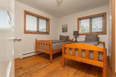 a bedroom with a bed and a couch and windows at Pet Friendly 3 Bdrm Home with Hot Tub by StayIn in Fernie