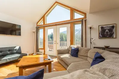 a living room with a couch and a table at Pet Friendly 3 Bdrm Home with Hot Tub by StayIn in Fernie