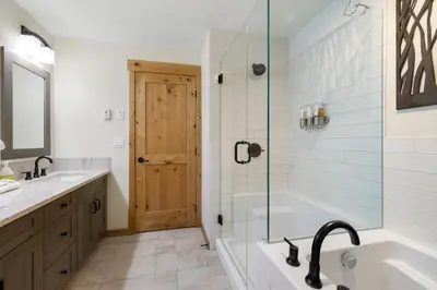 a bathroom with a tub and a sink and a shower at Spring Creek Corner Condo by Canadian Rockies Vacation Rentals in Canmore