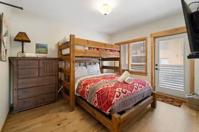 a bedroom with a bunk bed and a dresser at Spring Creek Corner Condo by Canadian Rockies Vacation Rentals in Canmore