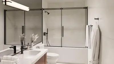 a bathroom with a shower and a toilet and a sink at The Como Hotel in Vancouver
