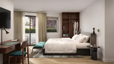 a bedroom with a bed and a desk and a computer at The Como Hotel in Vancouver