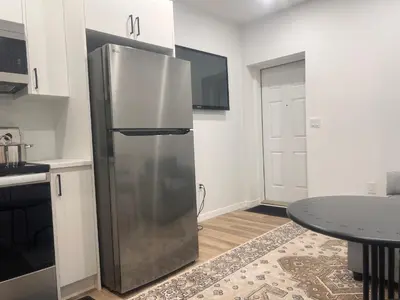 a stainless steel refrigerator in a kitchen with a table at Home sweet home in Calgary