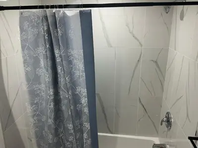 a shower with a blue shower curtain in a bathroom at Home sweet home in Calgary