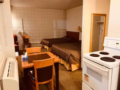 a small room with a kitchen and a bedroom at Red Carpet Inn & Suites in Calgary