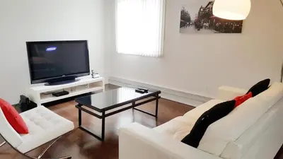 a living room with two white couches and a tv at Discover Tranquility in this 2 bed townhouse in Vancouver