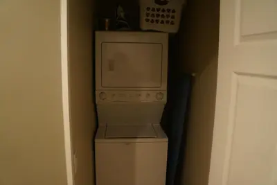 a microwave sitting on top of a washer and dryer at Discover Tranquility in this 2 bed townhouse in Vancouver