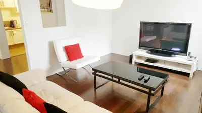 a living room with a white couch and a tv at Discover Tranquility in this 2 bed townhouse in Vancouver