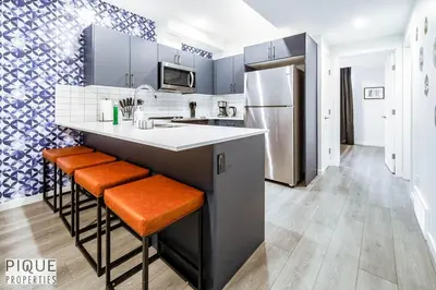 a kitchen with a counter and a refrigerator at NEW-The Suite Life-2BD-King Bed-WEM & YEG Airport in Edmonton