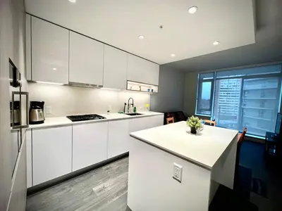 a kitchen with white cabinets and a large window at Exquisite 1bed 1 bath locates in city center in Richmond