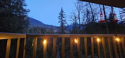 a deck with a fence with lights on it at Casa del Rio - Peaceful River Guest Suite -Forests -Mountains -Hiking in Chilliwack