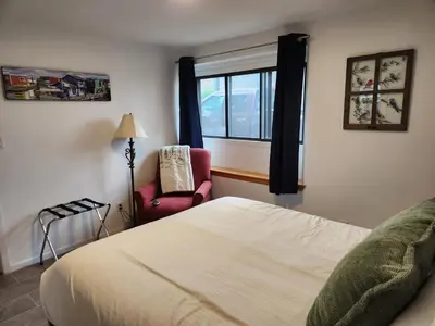 a bedroom with a bed and a chair and a window at D&G Suite Retreat in Sidney