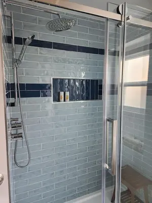 a bathroom with a shower with blue tiles at D&G Suite Retreat in Sidney