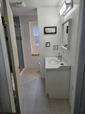 a white bathroom with a sink and a mirror at D&G Suite Retreat in Sidney