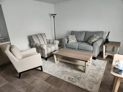 a living room with a couch and two chairs and a coffee table at D&G Suite Retreat in Sidney