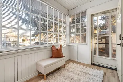 a room with a chair in front of windows at The Sandlot Family in Drumheller
