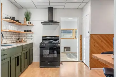 a kitchen with green cabinets and a stove in it at The Sandlot Family in Drumheller