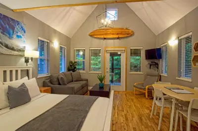 a bedroom with a bed and a living room at Tide and Trail- Cabin in Ucluelet in Ucluelet