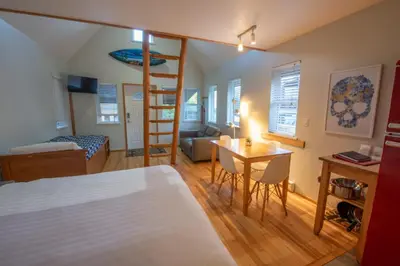 a bedroom with a loft bed and a living room at Surf Haven - Cabin in Ucluelet - Sleeps 5 in Ucluelet