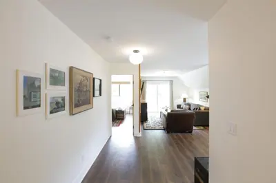a living room with white walls and wood floors at Raven Lady #201- Ucluelet Sleeps 6 Pet Friendly in Ucluelet