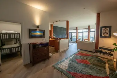 a room with a crib and a bedroom with a television at Big Beach Escape - Ucluelet - Sleeps 6 - Pet Friendly in Ucluelet