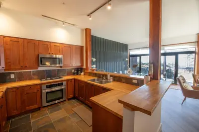 a kitchen with wooden cabinets and a counter top at Big Beach Escape - Ucluelet - Sleeps 6 - Pet Friendly in Ucluelet