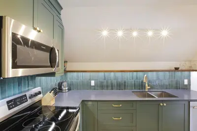 a kitchen with green cabinets and a sink and a microwave at Raven Lady #202- Ucluelet, Sleeps 4, Pet Friendly in Ucluelet