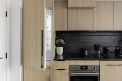 a kitchen with wooden cabinets and black counter tops at Keefer House in Vancouver