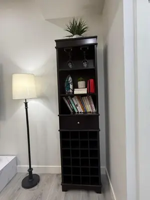 a black book shelf with a potted plant and a lamp at Maxti Guest Suite, Northwest Calgary in Calgary