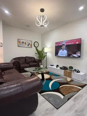 a living room with a couch and a flat screen tv at Maxti Guest Suite, Northwest Calgary in Calgary