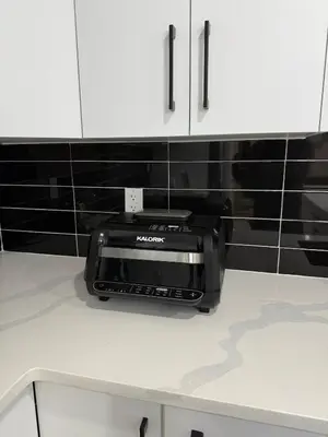 a toaster oven sitting on top of a kitchen counter at Maxti Guest Suite, Northwest Calgary in Calgary