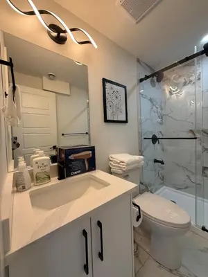 a bathroom with a sink and a toilet and a shower at Maxti Guest Suite, Northwest Calgary in Calgary