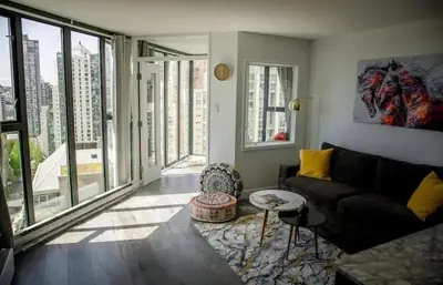 a living room with a couch and large windows at Luxury Ocean view Apartment- Heart of Yaletown Downtown Vancouver in Vancouver