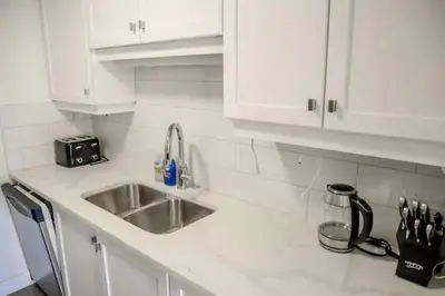 a kitchen counter with a sink and white cabinets at Luxury Ocean view Apartment- Heart of Yaletown Downtown Vancouver in Vancouver