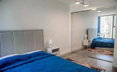 a bedroom with a blue bed and a window at Luxury Ocean view Apartment- Heart of Yaletown Downtown Vancouver in Vancouver