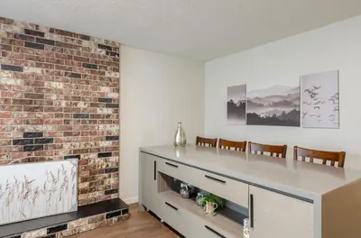 a living room with a fireplace and a brick wall at Convenient Urban Retreat in Vancouver