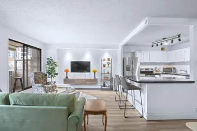 a kitchen and living room with a couch and a table at Stylish Suite at Stampede w Free Parking and AC in Calgary