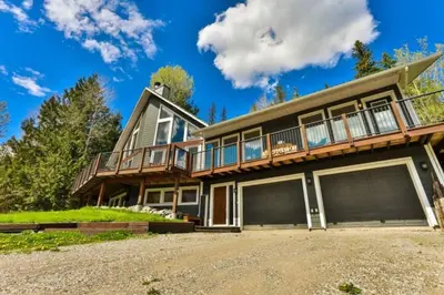 a large house with a porch and two garage at Dog friendly Home on Ski Hill with Hot Tub by StayIn in Fernie