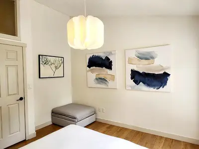 a bedroom with a bed and a chandelier at The OVERLOOK Stay-Mountain View-Free Parking in Canmore