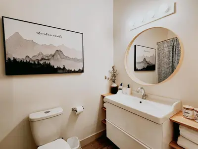 a bathroom with a sink and a mirror and a toilet at The OVERLOOK Stay-Mountain View-Free Parking in Canmore