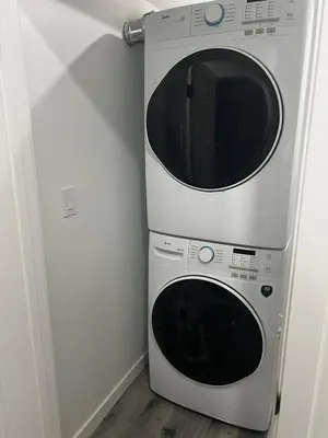 a white microwave oven sitting next to a refrigerator at Basement in Keswick Edmonton in Edmonton