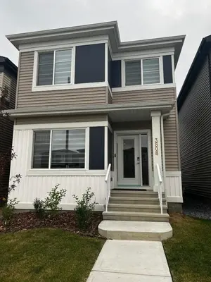 a gray house with a white door and stairs at Basement in Keswick Edmonton in Edmonton