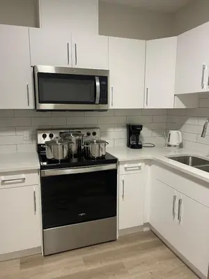 a kitchen with a stove and a microwave at Modern suite in basement Upland in Edmonton